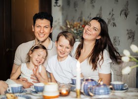 Cheerful family of four enjoying a warm and cozy teatime at home, surrounded by love and laughter.